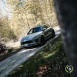 En luksuriøs Porsche Macan GTS parkeret på en grussti midt i en skov, der viser balancen mellem avanceret bildesign og roen i naturlige omgivelser.