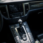 Luksuriøst Porsche Macan GTS-interiør med automatisk gearskifte, slank midterkonsol med touchskærm og elegante krom-accenter, der fremhæver sofistikeret og moderne bildesign.