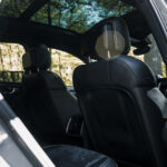 Billedet viser et luksuriøst Porsche Macan GTS interiør med slanke sorte lædersæder, et moderne design, sollys strømmer ind gennem det åbne tag og fokus på komfort og stil.