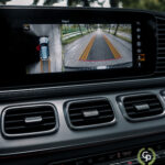 En hybrid SUVs moderne infotainmentsystem, som i Mercedes GLE350de, viser en delt skærm med et bakkamera til højre og en 360-graders parkeringsassistent