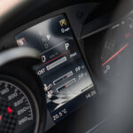 Nærbillede af en moderne Mercedes C43 cabriolets digitale instrumentbræt, der viser gearvalg, speedometer ved 0 mph, omdrejningstæller og forskellige temperaturaflæsninger.