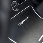 Billedet portrætterer den luksuriøse interiørdetalje af en Mercedes C43 Cabriolet, med et analogt ur og emblemet med angivelse af "amg", hvilket betyder Mercedes-Benz' præstationsopdeling, sat i forhold til en